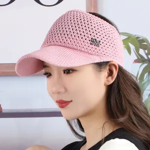 Close-up of pink knitted hollow-out empty top sun visor hat with rhinestone M logo.