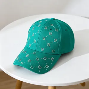 Gorra de béisbol verde con monograma B de pedrería, primer plano de patrón de cristal.