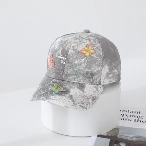 Close-up of grey tie-dye baseball cap featuring dazzling rhinestones and cute butterfly details.