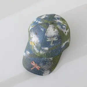 Detailed view of the rhinestone dragonfly tie dye baseball cap showing sparkling crystals.