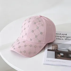 Detalle de gorra de béisbol rosa con hermosas piedras de estrás brillante y visera.
