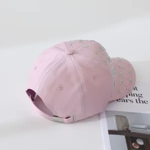 Gorra de béisbol rosa con letras de diamantes brillantes vista detallada de tela.