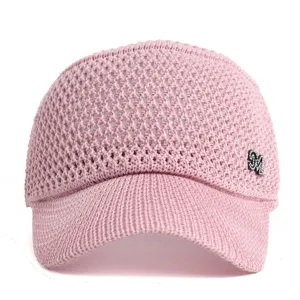 Close-up of the pink knit sun visor featuring a sparkling rhinestone M logo and breathable hollow design.