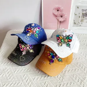 Detailed close-up view of colorful rhinestone butterfly baseball caps showing fine details.