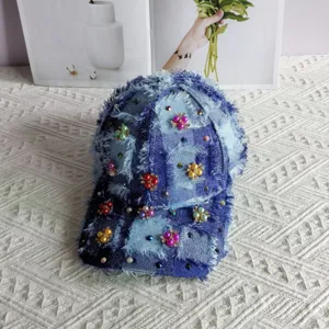 Cappellino da baseball in denim sfilacciato con perle e strass, accessorio di moda chic.