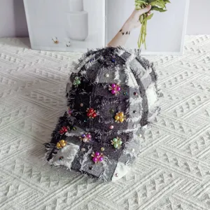 Berretto da baseball in tweed a quadri con fiori di perle strass e bordi sfrangiati.