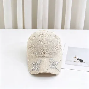 Cappello da baseball in maglia beige traforata con farfalla in strass e motivo corona parasole.
