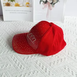 Dettaglio cappellino da baseball rosso con strass Queen, cappello da sole in cotone.