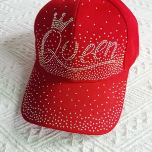 Primo piano dettaglio del berretto da baseball Queen con strass rossi, accessorio tendenza.