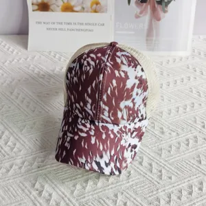 Detailed view of women printed mesh trucker hat, brown and white pattern, breathable back.