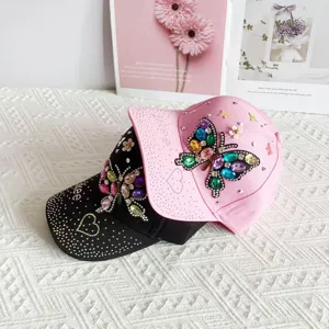 Close-up detail of rhinestone butterfly baseball cap with shiny colorful crystals.
