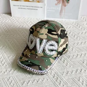 Close-up of camo baseball cap with handmade pearl rhinestone LOVE letters and beaded brim.