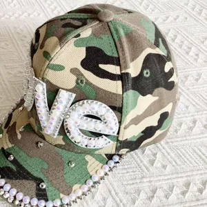 Camo baseball cap for women with handmade pearl rhinestone LOVE letter patch and brim detailing.