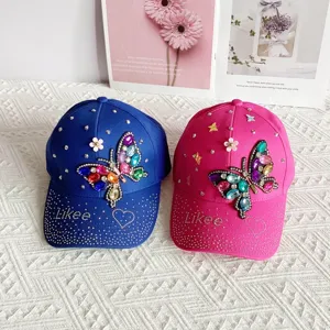 Detailed close-up of stylish rhinestone butterfly baseball cap with shiny gemstone decor.
