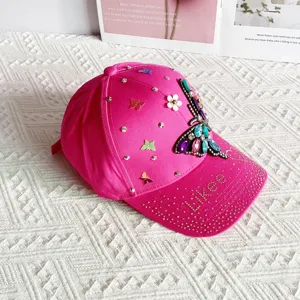 Detailed shot of pink rhinestone butterfly baseball cap, sparkly gems and floral accents, sun hat.