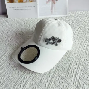 Detail view of white quick-dry baseball cap with rhinestone butterfly and solar fan component.