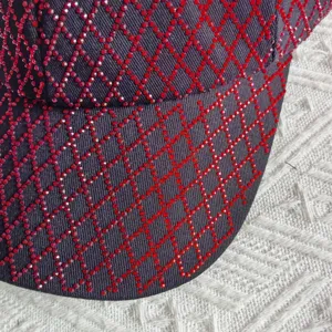 Rhinestone baseball cap detail, sparkling red crystal diamond lattice pattern on dark fabric.