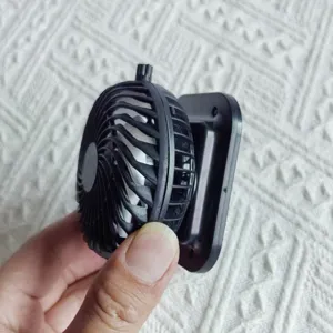 Portable mini clip-on fan module, compact black plastic personal cooling fan for daily use.