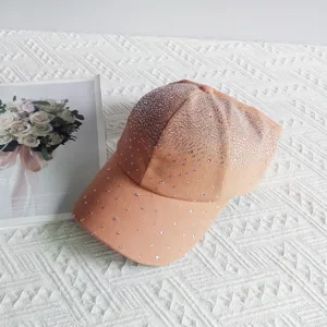 Detailed shot of a stylish women baseball cap with gorgeous gradient rhinestones, peach color.