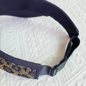 Vista detallada de la visera de mujer con banda de estampado de leopardo de diamantes y correa.