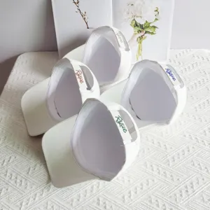 Detailed view of trendy white baseball caps featuring rhinestone back strap embroidery and adjustable fit.