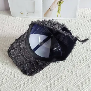 Dettaglio berretto da baseball in tweed sfrangiato, motivo scozzese grigio scuro, chic.