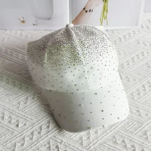 Detail view of sparkling rhinestone decorated half-empty top white baseball cap closeup.