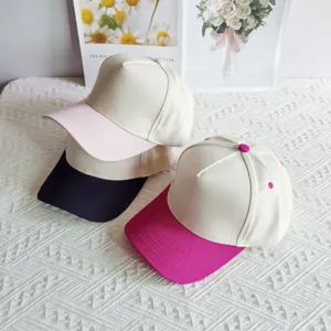 Details of the contrast color five-panel baseball cap showing stitching, brim and button.