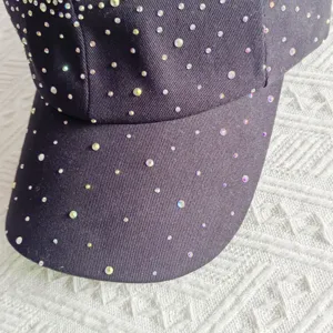 Close-up detail of a sparkling rhinestone black baseball cap, showing exquisite star crystal decor.