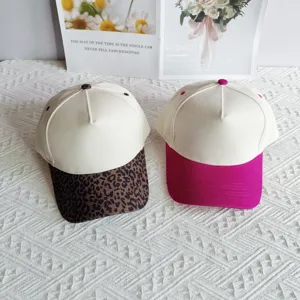 Detailed view of colorblocked baseball caps with leopard and pink brims, cotton five-panel design.
