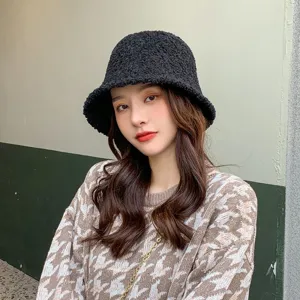 Detailed shot of a black fleece bucket hat worn by a model, showcasing texture and brim style.