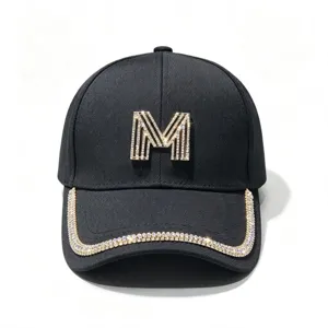 Black baseball cap with rhinestone M logo and sparkling crystal brim for women fashion.