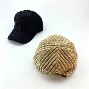 Detailed close-up of corduroy winter caps in black and khaki, showing soft fabric texture.