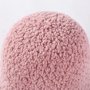 Close-up detail of soft pink sherpa fleece bucket hat fabric, showing fluffy warm winter texture.