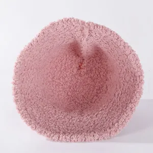 Pink fuzzy bucket hat detail view, soft shearling fleece winter warm fisherman cap.