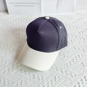 Details of the color block baseball cap showing pure cotton fabric and visor stitching.