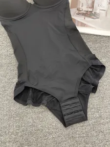 Detailed view of black shaping bodysuit, featuring breathable mesh and secure hook closure.