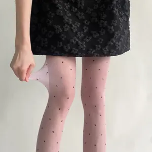 Gros plan de collants transparents à pois roses montrant une grande élasticité et un tissu doux.