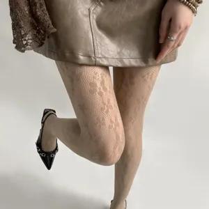 Vue détaillée de collants résille floraux marron pour femme, motif dentelle délicat et ajusté.