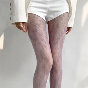 Gros plan de collants résille à fleurs violettes pour femmes, bas en dentelle élégants de printemps.