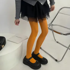 Detailed view of vibrant yellow velvet tights showcasing smooth texture and autumn wear styling.