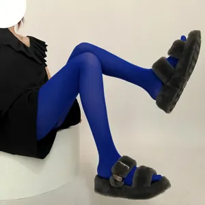 Detailed view of vibrant blue velvet pantyhose paired with cozy furry slide sandals in style.