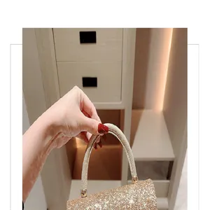 Detail view of a shiny glitter evening handbag with metal handle for luxury party dress.