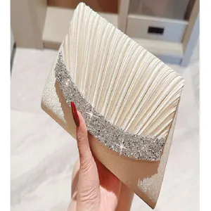 Detail shot of an elegant pleated evening clutch bag with sparkling rhinestone flap design.