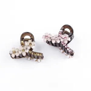 Vista dettagliata di due eleganti mollette per capelli a fiore decorate con strass scintillanti.