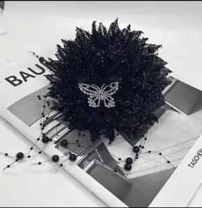 Nahaufnahme der schwarzen glitzernden Blumenhaarklammer mit funkelndem Kristallschmetterling.