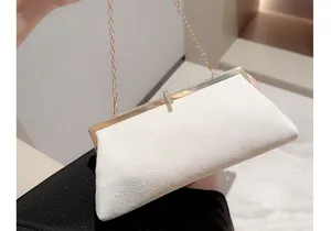 Gros plan d'une pochette de soirée en velours blanc avec chaîne en métal et fermoir strass.