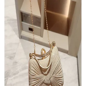 Detailed view of luxury sparkling evening clutch bag with rhinestone metal frame and chain strap.
