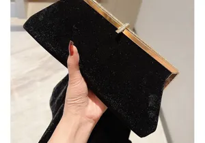 Vue detaillee exquise d'une pochette de soiree en velours noir avec fermoir en strass.