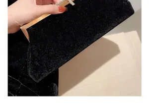 Gros plan sur la pochette de soirée en velours noir, avec cadre doré et strass scintillants.